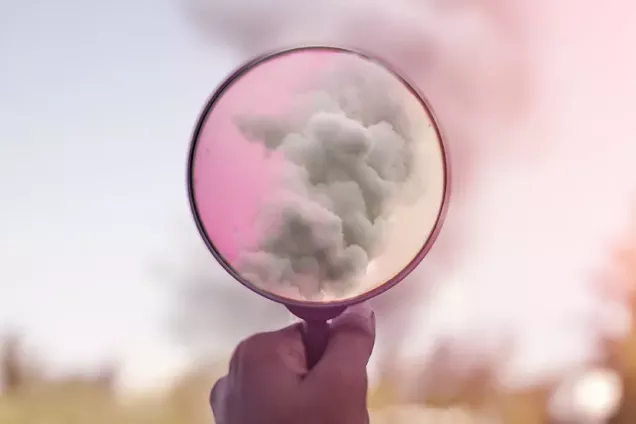 magnifying glass pointed at pink sky and clouds. photo