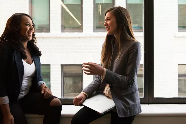 two women laughing and talking