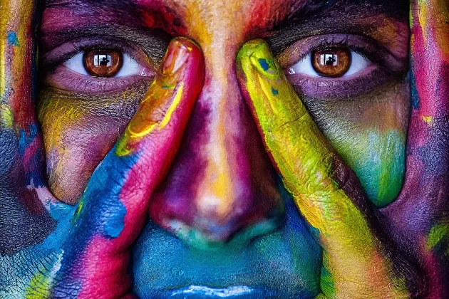 Foto av kvinna med massor olika färger i ansiktet.